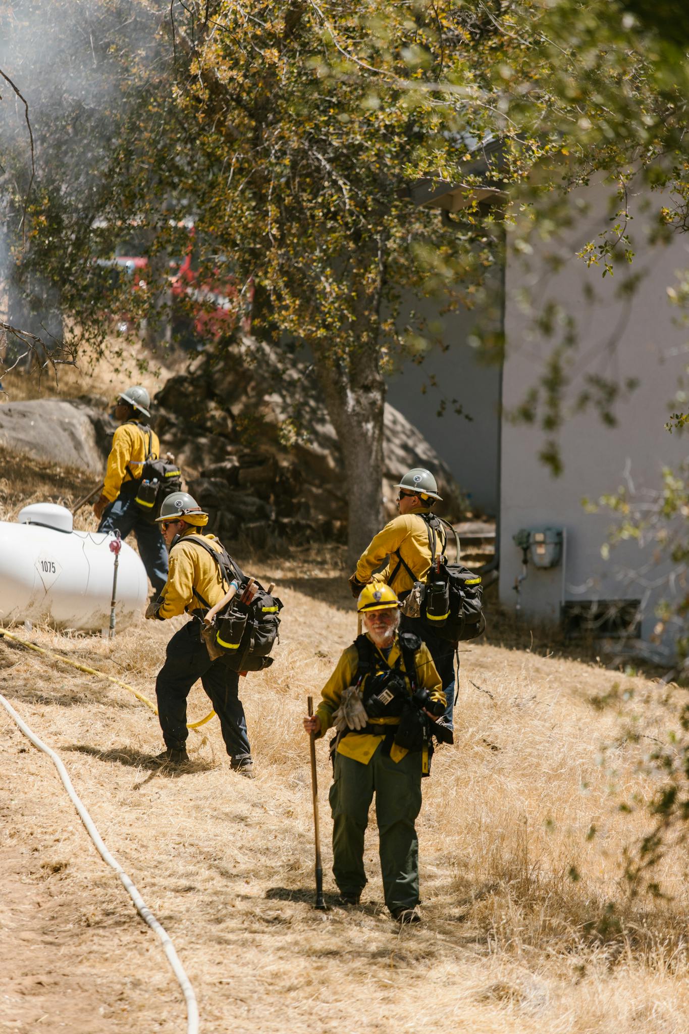 Brave firefighters work together to control a wildfire in a dry, rural environment.
